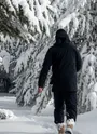 Raquettiste faisant ses traces dans la neige fraiche sous les arbres