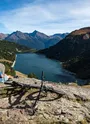 Vttiste admirant la vue sur les barrages depuis un promontoir en pierre